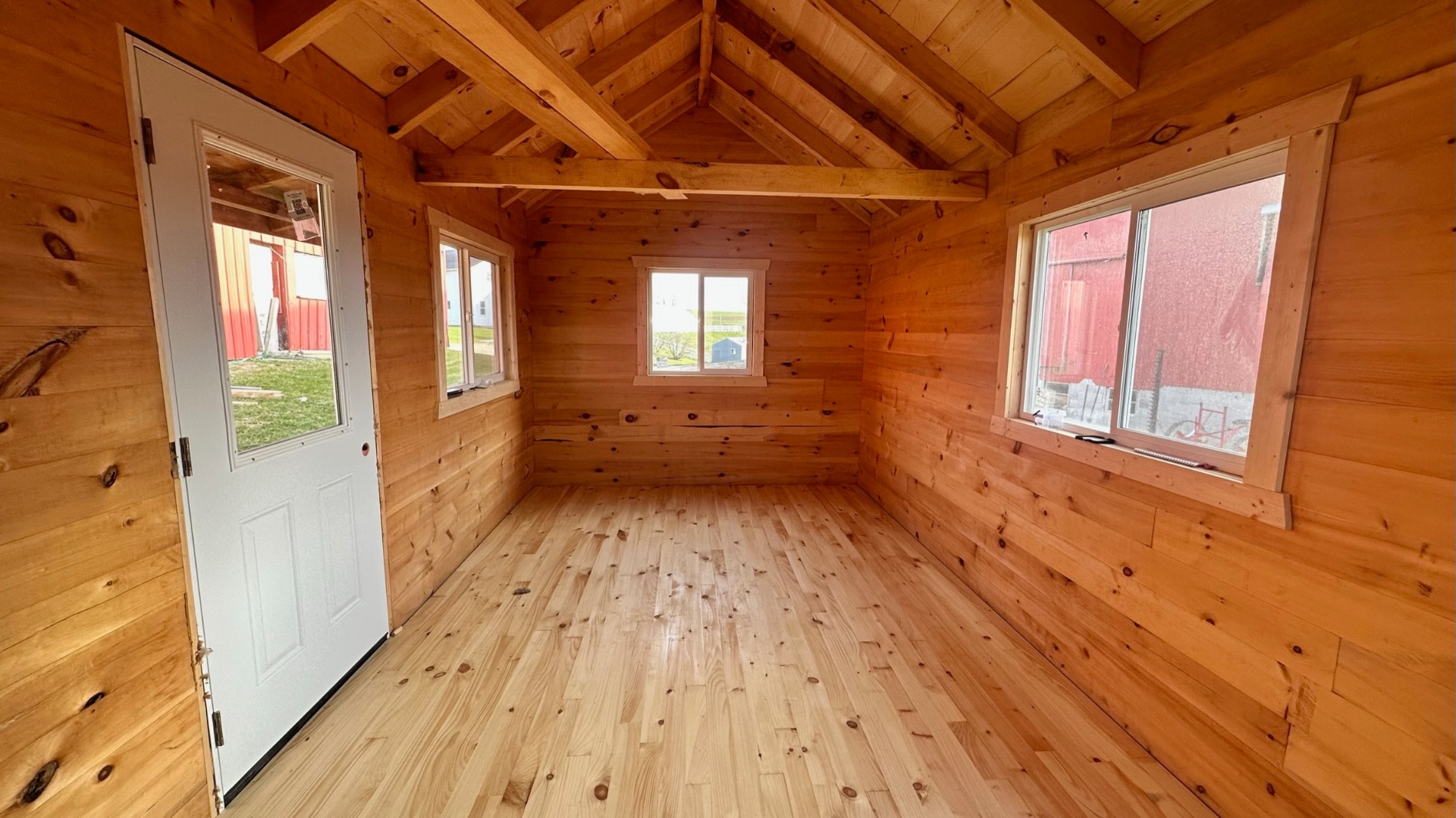 Cabin interior with exposed rafters and side door