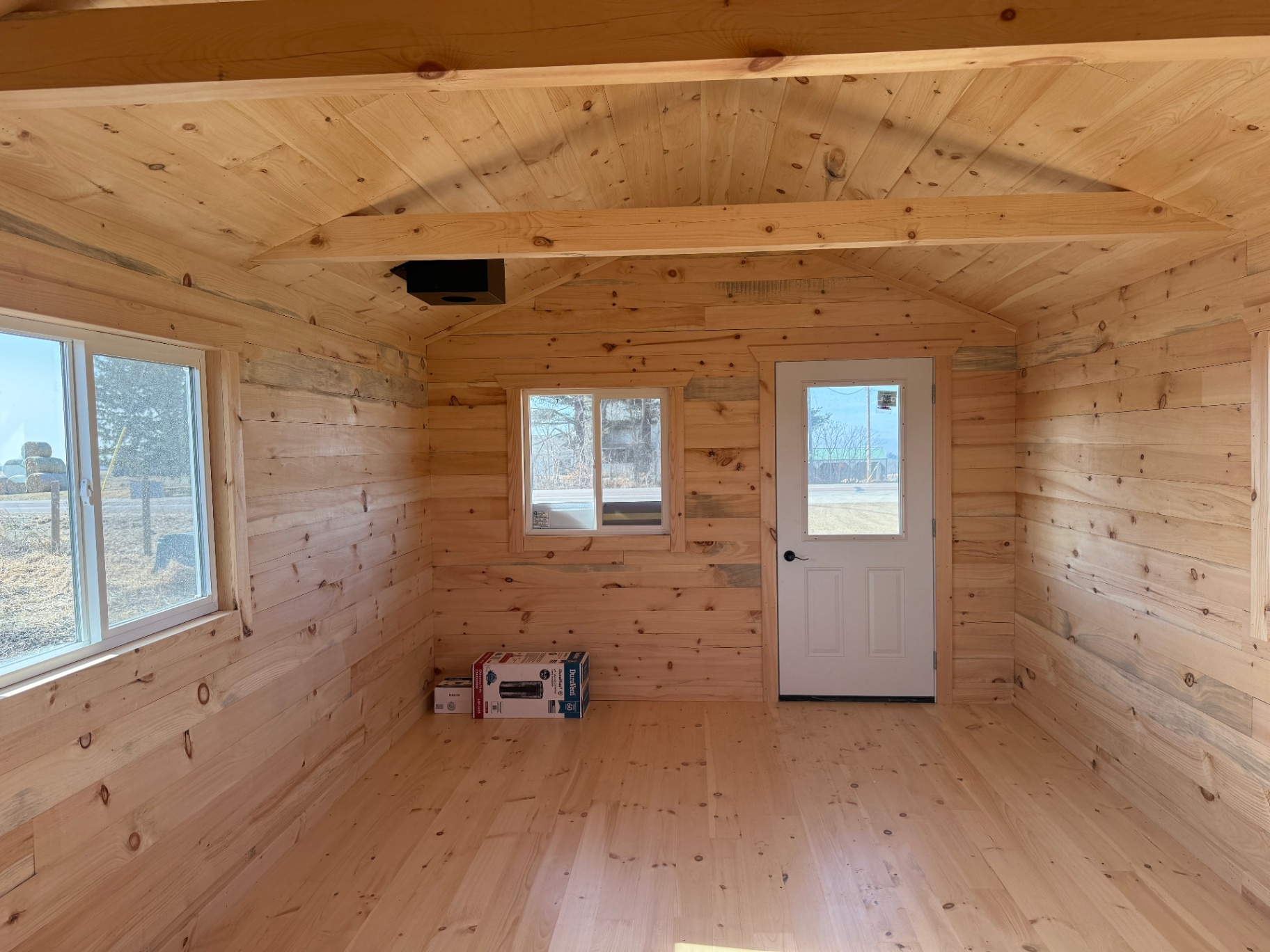 Wide cabin interior with large window and exposed beams